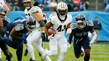 Alvin Kamara running past defenders in Week 16's game in Tennessee