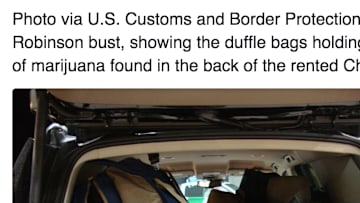 Photo showing Greg Robinson using duffle bags to carry 157 pounds of marijuana
