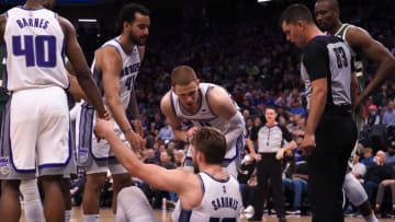 Mar 16, 2022; Sacramento, California, USA; Sacramento Kings center Domantas Sabonis (10) is helped up by teammates forward Harrison Barnes (40), forward Trey Lyles (41) and guard Donte DiVincenzo (0) after a play against the Milwaukee Bucks during the second quarter at Golden 1 Center. Mandatory Credit: Kelley L Cox-USA TODAY Sports