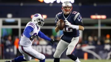 Nov 23, 2015; Foxborough, MA, USA; New England Patriots quarterback Tom Brady (12) scrambles away from Buffalo Bills defensive end Mario Williams (94) during the first half at Gillette Stadium. Mandatory Credit: Winslow Townson-USA TODAY Sports
