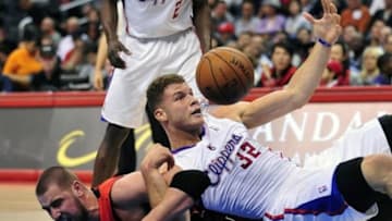 February 7, 2014; Los Angeles, CA, USA; Los Angeles Clippers power forward Blake Griffin (32) plays for a loose ball against Toronto Raptors center Jonas Valanciunas (17) during the first half at Staples Center. Mandatory Credit: Gary A. Vasquez-USA TODAY Sports