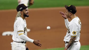 ARLINGTON, TEXAS - OCTOBER 08: Fernando Tatis Jr. #23 of the San Diego Padres talks with Manny Machado #13 during the eighth inning against the Los Angeles Dodgers in Game Three of the National League Division Series at Globe Life Field on October 08, 2020 in Arlington, Texas. (Photo by Ronald Martinez/Getty Images)