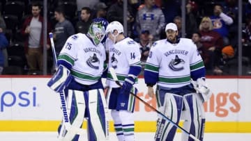 Feb 9, 2016; Denver, CO, USA; Vancouver Canucks goalie Jacob Markstrom (25) and left wing Alex Burrows (14) and goalie Ryan Miller (30) celebrate the win over the Colorado Avalanche at the Pepsi Center. The Canucks defeated the Avalanche 3-1. Mandatory Credit: Ron Chenoy-USA TODAY Sports