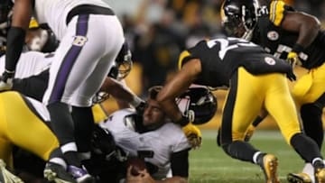 Nov 2, 2014; Pittsburgh, PA, USA; Baltimore Ravens quarterback Joe Flacco (5) is elbowed in the head by Pittsburgh Steelers safety Mike Mitchell (23) after losing his helmet during the first half of the game at Heinz Field. Mandatory Credit: Jason Bridge-USA TODAY Sports