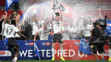 LONDON, ENGLAND - AUGUST 04: Tom Cairney of Fulham lifts the trophy as the team celebrate victory after the Sky Bet Championship Play Off Final match between Brentford and Fulham at Wembley Stadium on August 04, 2020 in London, England. Football Stadiums around Europe remain empty due to the Coronavirus Pandemic as Government social distancing laws prohibit fans inside venues resulting in all fixtures being played behind closed doors. (Photo by Shaun Botterill/Getty Images)