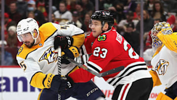 CHICAGO, ILLINOIS - DECEMBER 17: Philipp Kurashev #23 of the Chicago Blackhawks and Alexandre Carrier #45 of the Nashville Predators battle for position in front of Juuse Saros #74 at the United Center on December 17, 2021 in Chicago, Illinois. The Predators defeated the Blackhawks 3-2 in overtime. (Photo by Jonathan Daniel/Getty Images)
