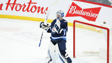 Apr 27, 2022; Winnipeg, Manitoba, CAN; Winnipeg Jets goalie Eric Comrie (1) celebrates their win against the Philadelphia Flyers at the end of the third period at Canada Life Centre. Mandatory Credit: Terrence Lee-USA TODAY Sports