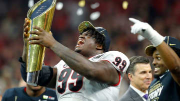 Georgia Bulldogs defensive lineman Jordan Davis (99) hoists the trophy