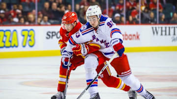 Nov 12, 2016; Calgary, Alberta, CAN; New York Rangers center Mika Zibanejad (93) and Calgary Flames left wing Johnny Gaudreau (13) battle for the puck during the third period at Scotiabank Saddledome. New York Rangers won 4-1. Mandatory Credit: Sergei Belski-USA TODAY Sports