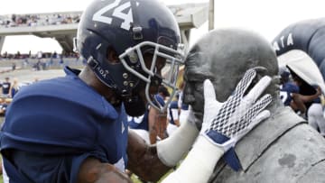 Cornerback Riyahd Jones #24 of the Georgia Southern Eagles hugs the Erk Russell statue Bennett/GettyImages)