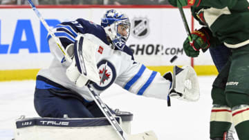 Apr 11, 2023; Saint Paul, Minnesota, USA; Winnipeg Jets goalie Connor Hellebuyck (37) fights through traffic to make a save against the Minnesota Wild during the second period at at Xcel Energy Center. Mandatory Credit: Nick Wosika-USA TODAY Sports
