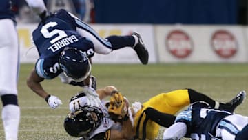 Luke Tasker #17 of the Hamilton Tiger-Cats is tackled by Jermaine Gabriel #5 of the Toronto Argonauts. (Photo by Dave Sandford/Getty Images)