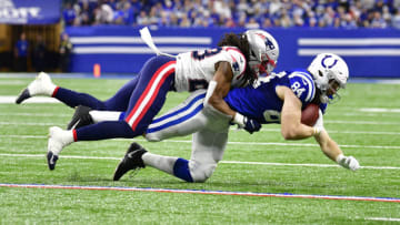 Dec 18, 2021; Indianapolis, Indiana, USA; New England Patriots safety Kyle Dugger (23) tackles Indianapolis Colts tight end Jack Doyle (84) during the second half at Lucas Oil Stadium. Colts won 27-17. Mandatory Credit: Marc Lebryk-USA TODAY Sports