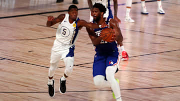 LAKE BUENA VISTA, FLORIDA - AUGUST 01: Edmond Sumner #5 of the Indiana Pacers and Joel Embiid #21 of the Philadelphia 76ers compete for the ball during the second quarter of an NBA basketball game at the Visa Athletic Center in the ESPN Wide World Of Sports Complex on August 1, 2020 in Lake Buena Vista, Florida. NOTE TO USER: User expressly acknowledges and agrees that, by downloading and or using this photograph, User is consenting to the terms and conditions of the Getty Images License Agreement. (Photo by Kim Klement - Pool/Getty Images)