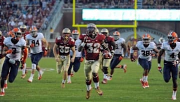 Nov 16, 2013; Tallahassee, FL, USA; Florida State Seminoles running back James Wilder Jr. (32) runs the ball for a touchdown past Syracuse Orange cornerbck Brandon Reddish (4), linebacker Cameron Lynch (38) and free safety Durell Eskridge (3) during the second half at Doak Campbell Stadium. Mandatory Credit: Melina Vastola-USA TODAY Sports