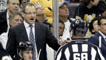 Mar 27, 2014; Pittsburgh, PA, USA; Pittsburgh Penguins head coach Dan Bylsma (top left) reacts to linesman Scott Driscoll (68) after a Penguins goal was disallowed for goal tender interference against the Los Angeles Kings during the third period at the CONSOL Energy Center. The Kings won 3-2. Mandatory Credit: Charles LeClaire-USA TODAY Sports