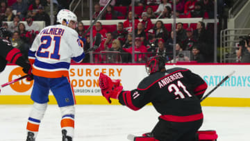 Apr 2, 2023; Raleigh, North Carolina, USA; Carolina Hurricanes goaltender Frederik Andersen (31) reaches for a save against New York Islanders center Kyle Palmieri (21) during the second period at PNC Arena. Mandatory Credit: James Guillory-USA TODAY Sports