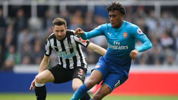 NEWCASTLE UPON TYNE, ENGLAND - APRIL 15: Paul Dummett of Newcastle United and Alex Iwobi of Arsenal battle for possession during the Premier League match between Newcastle United and Arsenal at St. James Park on April 15, 2018 in Newcastle upon Tyne, England. (Photo by Stu Forster/Getty Images)