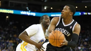 Feb 22, 2014; Oakland, CA, USA; Brooklyn Nets shooting guard Joe Johnson (7) controls the ball against Golden State Warriors small forward Draymond Green (23) during the first quarter at Oracle Arena. Mandatory Credit: Kelley L Cox-USA TODAY Sports