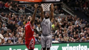 Jan 2, 2016; San Antonio, TX, USA; San Antonio Spurs small forward Kawhi Leonard (2) dunks the ball past Houston Rockets small forward Trevor Ariza (1) during the first half at AT&T Center. Mandatory Credit: Soobum Im-USA TODAY Sports