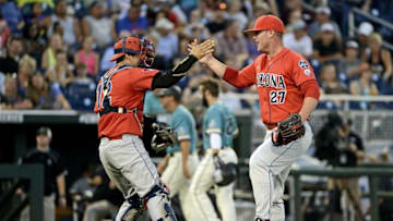 Jun 27, 2016; Omaha, NE, USA; Arizona Wildcats starting pitcher JC Cloney (27) hugs catcher catcher Cesar Salazar (12) after defeating the Coastal Carolina Chanticleers in game one of the College World Series championship series at TD Ameritrade Park. Mandatory Credit: Steven Branscombe-USA TODAY Sports