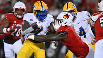 Oct 22, 2022; Louisville, Kentucky, USA; Pittsburgh Panthers running back Israel Abanikanda (2) tries to break free from the tackle of Louisville Cardinals defensive lineman YaYa Diaby (6) as he runs the ball during the first half at Cardinal Stadium. Louisville defeated Pittsburgh 24-10. Mandatory Credit: Jamie Rhodes-USA TODAY Sports