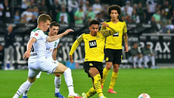 Dortmund's Dutch forward Donyell Malen (C) and Moenchengladbach's German defender Matthias Ginter (L) vie for the ball during the German first division Bundesliga football match Borussia Moenchengladbach v BVB Borussia Dortmund in Moenchengladbach, western Germany, on September 25, 2021. - DFL REGULATIONS PROHIBIT ANY USE OF PHOTOGRAPHS AS IMAGE SEQUENCES AND/OR QUASI-VIDEO (Photo by UWE KRAFT / AFP) / DFL REGULATIONS PROHIBIT ANY USE OF PHOTOGRAPHS AS IMAGE SEQUENCES AND/OR QUASI-VIDEO (Photo by UWE KRAFT/AFP via Getty Images)
