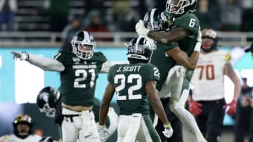 EAST LANSING, MI - NOVEMBER 30: Safety David Dowell #6 of the Michigan State Spartans celebrates in the arms of safety Xavier Henderson #3 along with linebacker Chase Kline #21 and cornerback Josiah Scott #22 celebrating after stopping the Maryland Terrapins during the fourth quarter at Spartan Stadium on November 30, 2019, in East Lansing, Michigan. Michigan State defeated Maryland 19-16. (Photo by Duane Burleson/Getty Images)
