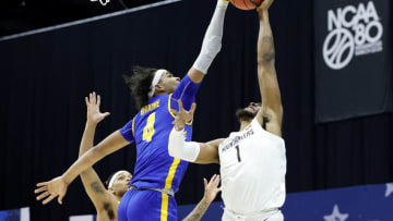 INDIANAPOLIS, INDIANA - MARCH 19: Johni Broome #4 of the Morehead State Eagles blocks a shot by Derek Culver #1 of the West Virginia Mountaineers in the first round game of the 2021 NCAA Men's Basketball Tournament at Lucas Oil Stadium on March 19, 2021 in Indianapolis, Indiana. (Photo by Tim Nwachukwu/2021 Getty Images)