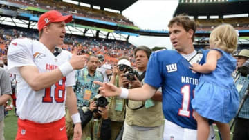 January 27, 2013; Honolulu, HI, USA; AFC quarterback Peyton Manning of the Denver Broncos (18, left) shakes hands with NFC quarterback Eli Manning of the New York Giants (10, right) after the 2013 Pro Bowl at Aloha Stadium. The NFC defeated the AFC 62-35. Mandatory Credit: Kyle Terada-USA TODAY Sports