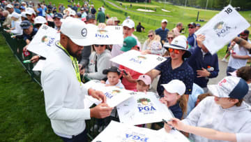 ROCHESTER, NEW YORK - MAY 16: Tony Finau of the United States signs his autograph for a fan during a practice round prior to the 2023 PGA Championship at Oak Hill Country Club on May 16, 2023 in Rochester, New York. (Photo by Michael Reaves/Getty Images)