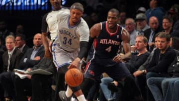 Apr 11, 2014; Brooklyn, NY, USA; Brooklyn Nets small forward Paul Pierce (34) chases a loose ball with Atlanta Hawks power forward Paul Millsap (4) during the second quarter of a game at Barclays Center. Mandatory Credit: Brad Penner-USA TODAY Sports