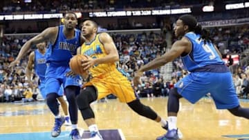 Feb 22, 2013; New Orleans, LA, USA; New Orleans Hornets guard Eric Gordon (10) drives toward the basket between Dallas Mavericks center Bernard James (5) and Jae Crowder (9) during the first quarter at the New Orleans Arena. Mandatory Credit: Crystal LoGiudice-USA TODAY Sports