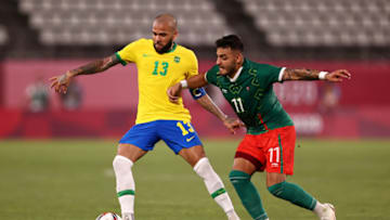 Dani Alves (left) battles Alexis Vega during the 2020 Olympics. The pair might meet again in Liga MX play when the Pumas tangle with the Chivas in late August. (Photo by Buda Mendes/Getty Images)