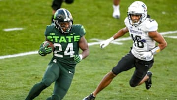 Michigan State's Elijah Collins, left, runs for a gain as Northwestern's Brandon Joseph closes in during the first quarter on Saturday, Nov. 28, 2020, at Spartan Stadium in East Lansing.201128 Msu Northwestern 087a