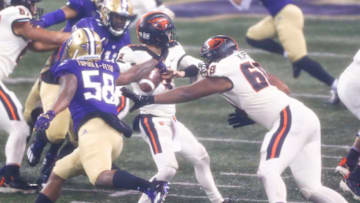 Nov 14, 2020; Seattle, Washington, USA; Washington Huskies linebacker Zion Tupuola-Fetui (58) strips Oregon State Beavers quarterback Tristan Gebbia (3) of the ball during the second quarter at Alaska Airlines Field at Husky Stadium. The Oregon State Beavers recovered the fumble. Mandatory Credit: Joe Nicholson-USA TODAY Sports