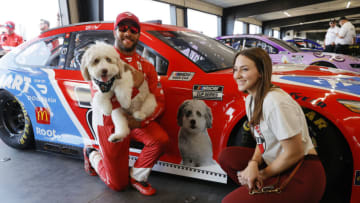LEBANON, TENNESSEE - JUNE 20: Bubba Wallace, driver of the #23 DoorDash/PetSmart Toyota, girlfriend, Amanda Carter, and pet dog, Asher pose for photos in the garage area during qualifying for the NASCAR Cup Series Ally 400 at Nashville Superspeedway on June 20, 2021 in Lebanon, Tennessee. (Photo by Sarah Stier/Getty Images)
