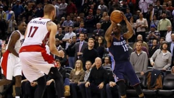 Dec 18, 2013; Toronto, Ontario, CAN; Charlotte Bobcats guard Kemba Walker (15) goes to shoot the game winning basket as Toronto Raptors center Jonas Valanciunas (17) defends at the Air Canada Centre. Charlotte defeated Toronto 104-102 in overtime. Mandatory Credit: John E. Sokolowski-USA TODAY Sports