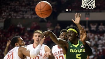 Mar 1, 2016; Norman, OK, USA; Baylor Bears forward Johnathan Motley (5) passes the ball while guarded by Oklahoma Sooners guard Jordan Woodard (10) during the first halt at Lloyd Noble Center. Mandatory Credit: Mark D. Smith-USA TODAY Sports