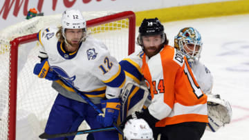 Feb 27, 2021; Buffalo, New York, USA; Buffalo Sabres center Eric Staal (12) and Philadelphia Flyers center Sean Couturier (14) battle for position in from of Buffalo goaltender Carter Hutton (40) during the third period at KeyBank Center. Mandatory Credit: Timothy T. Ludwig-USA TODAY Sports