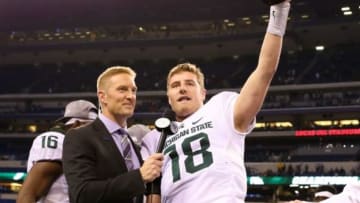 Dec 5, 2015; Indianapolis, IN, USA; Michigan State Spartans quarterback Connor Cook (18) holds up the Archie Griffin trophy for MVP as FOX emcee Joel Klatt interviews after the game against the Iowa Hawkeyes in the Big Ten Conference football championship at Lucas Oil Stadium. Michigan State won 16-13. Mandatory Credit: Aaron Doster-USA TODAY Sports