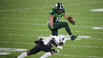 Nov 28, 2020; East Lansing, Michigan, USA; Michigan State Spartans running back Connor Heyward (11) leaps over Northwestern Wildcats defensive back A.J. Hampton (11) as he looses control of the football during the fourth quarter at Spartan Stadium. Mandatory Credit: Tim Fuller-USA TODAY Sports