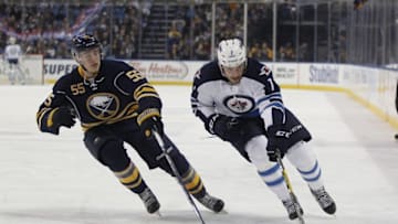 Mar 26, 2016; Buffalo, NY, USA; Winnipeg Jets defenseman Ben Chiarot (7) skates to the net with the puck while being defended by Buffalo Sabres defenseman Rasmus Ristolainen (55) during the first period at First Niagara Center. Mandatory Credit: Timothy T. Ludwig-USA TODAY Sports
