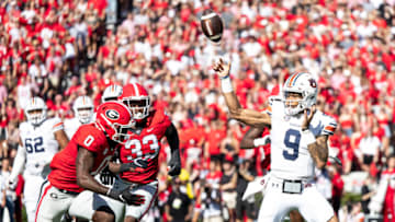 ATHENS, GA - OCTOBER 8: Robby Ashford #9 of the Auburn Tigers releases the ball quickly under pressure by Rian Davis #0 and Robert Beal Jr. #33 of the Georgia Bulldogs during a game between Auburn Tigers and Georgia Bulldogs at Sanford Stadium on October 8, 2022 in Athens, Georgia. (Photo by Steve Limentani/ISI Photos/Getty Images)