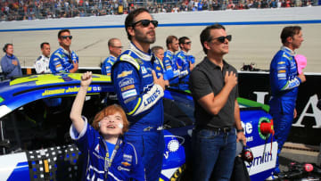 DOVER, DE - OCTOBER 01: Jimmie Johnson (C), driver of the #48 Lowe's Chevrolet, stands on the grid during the National Anthem prior to the Monster Energy NASCAR Cup Series Apache Warrior 400 presented by Lucas Oil at Dover International Speedway on October 1, 2017 in Dover, Delaware. (Photo by Chris Trotman/Getty Images)