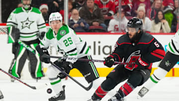 Dec 17, 2022; Raleigh, North Carolina, USA; Carolina Hurricanes defenseman Jalen Chatfield (5) and Dallas Stars left wing Joel Kiviranta (25) go after the puck during the second period at PNC Arena. Mandatory Credit: James Guillory-USA TODAY Sports
