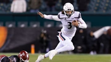 Cincinnati Bearcats quarterback Evan Prater is tackled by Temple Owls linebacker Jordan Magee. USA Today.
