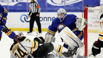 Apr 20, 2021; Buffalo, New York, USA; Boston Bruins left wing Jake DeBrusk (74) gets knocked down in front of Buffalo Sabres goaltender Dustin Tokarski (31) as he looks for the puck during the third period at KeyBank Center. Mandatory Credit: Timothy T. Ludwig-USA TODAY Sports