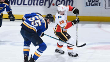 ST. LOUIS, MO - DECEMBER 16: Colton Parayko #55 of the St. Louis Blues and Elias Lindholm #28 of the Calgary Flames battle for control of the puck at Enterprise Center on December 16, 2018 in St. Louis, Missouri. (Photo by Joe Puetz/NHLI via Getty Images)