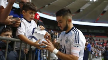 Oct 23, 2016; Vancouver, British Columbia, CAN; Vancouver Whitecaps FC midfielder Pedro Morales (77) signs an autograph for a fan following a 4-1 victory against the Portland Timbers at BC Place. Mandatory Credit: Joe Nicholson-USA TODAY Sports